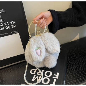 Gros plan sur le sac lapin en peluche grise avec poignée dorée et bandoulière perle