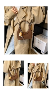 Détail d'un sac à bandoulière en daim marron en forme de croissant avec chaîne dorée