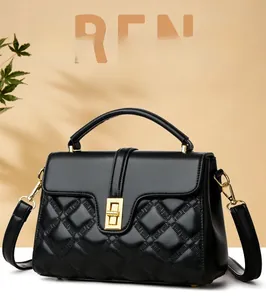 Detail of black quilted leather handbag showing golden rotary lock and refined textures