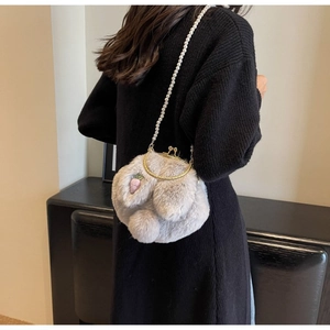 Gros plan d'un sac bandoulière peluche lapin avec bandoulière perles et broderie fraise