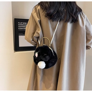 Détail du sac bandoulière lapin en peluche noire avec chaîne en perles et broderie carotte