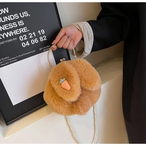 Détail du sac à main en peluche forme lapin avec écusson carotte et anneau doré