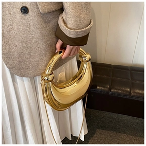 Détail du sac de soirée doré en forme de croissant avec poignée anneau nouée chic