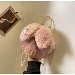 Gros plan du sac lapin en peluche rose avec chaîne perlée et poignée en métal pour femme