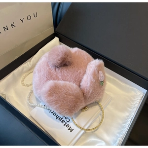 Détail du sac bandoulière en fausse fourrure rose avec broderie fraise dans un coffret cadeau