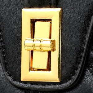 Detail of elegant gold twist lock hardware on black lychee texture leather handbag