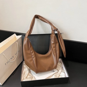 Caramel brown crescent shoulder bag with knotted strap detail in a luxury gift box