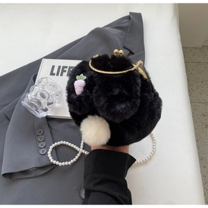 Détail du sac lapin en peluche noire avec pompon blanc et bandoulière en perles nacrées