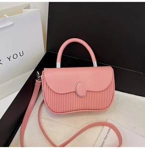 Detail view of pink PU leather handbag with elegant pleated texture and metal magnetic closure