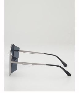 Detail view of large geometric sunglasses showing hollow metal temples and dark lenses