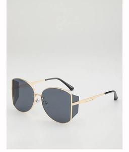 Detail of oversized geometric sunglasses with gold metal frame and dark tinted lenses