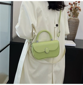 Detail view of avocado green leather tote bag with vertical pleats and silver metal buckle