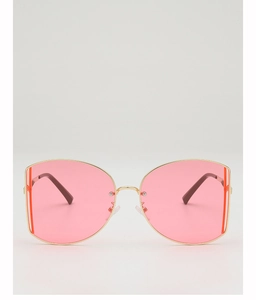 Detail of oversized gold metal frames with translucent pink lenses and black tips