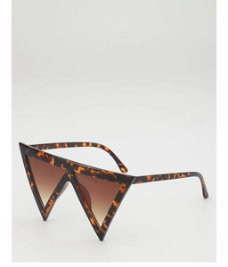Detail view of oversized triangle sunglasses with tortoiseshell frame and brown lenses