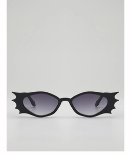 Close-up of black bat-wing shaped sunglasses with grey gradient lenses for Halloween