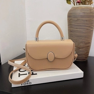 Chic beige crossbody handbag with pleated leather detail and elegant metal lock closure