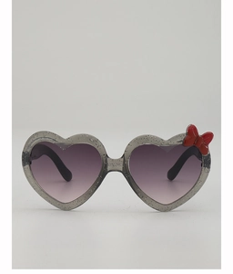 Détail de lunettes de soleil coeur enfant avec nœud rouge et monture pailletée