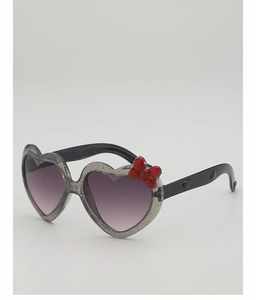 Détail de lunettes de soleil cœur pailletées pour enfants avec nœud rouge et verres violets