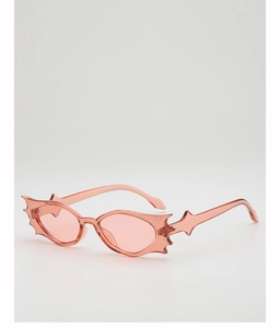 Close-up of pink translucent bat-shaped batwing sunglasses in gothic Y2K street style