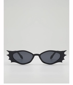 Macro detail of gothic bat-shaped sunglasses with black matte frames and grey lenses