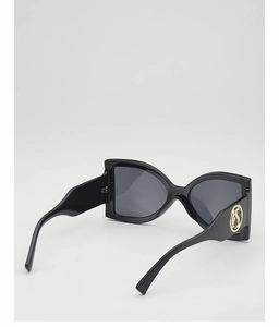 Detail of oversized black sunglasses showing gold round logo on wide temples