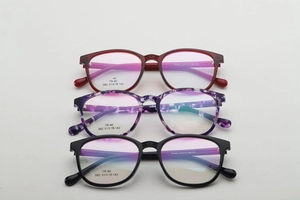 Detailed stack of TR90 glasses frames in burgundy, floral purple and classic black colors