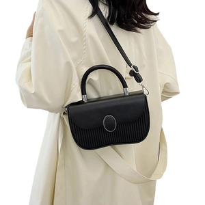 Minimalist black tote bag with vertical pleated texture and silver oval buckle detail