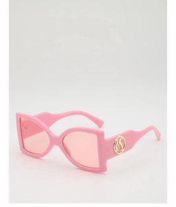 Close-up of pink oversized sunglasses frame with elegant golden metal circular logo