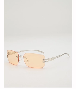 Detail of Y2K rimless sunglasses with orange lenses and silver star metal accents