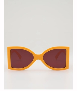 Close-up of oversized orange bow-shaped frame sunglasses with dark red gradient lenses