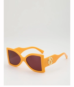 Detail view of bold orange frames with gold logo accents and deep reddish-brown lenses