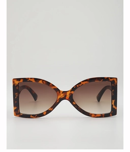 Detail of oversized tortoise shell sunglasses with wide temples and gradient lenses
