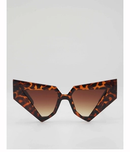Close-up of tortoise shell geometric sunglasses with brown gradient lenses and bold frames