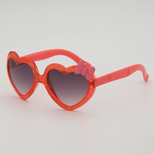 Lunettes de soleil coeur pour enfants avec paillettes, nœud rose et verres dégradés, vue 45°