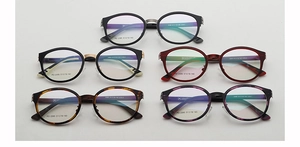 Gros plan de cinq montures de lunettes rondes élégantes en divers coloris et pont métallique
