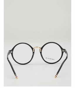 Detailed view of round eyewear frames featuring gold bridge and signature tri-color tips