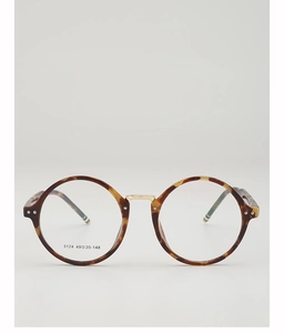Detail of round tortoiseshell frames with a gold metal bridge and engraved texture