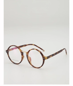 Detail of round tortoiseshell glasses frames with gold bridge and striped temple tips