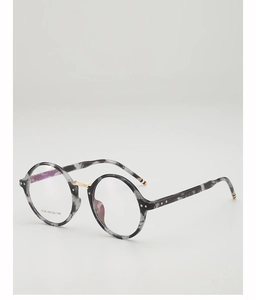 Macro detail of retro round tortoiseshell frame with gold metal bridge and tricolor tips