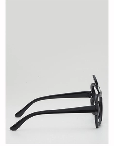 Macro side view of black glossy apple-shaped novelty sunglasses with wavy frame edges
