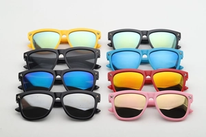 Flat lay of eight colorful kids sunglasses with star rivets and reflective mirror lenses