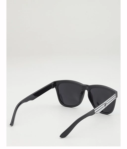 Detail of black sunglasses with silver stripes and a gesture logo on the side temple