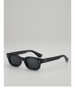 Dettaglio di occhiali da sole neri in acetato con rivetti in metallo stile vintage