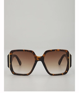 Detail of square tortoiseshell sunglasses frame with gold metal bar on temple