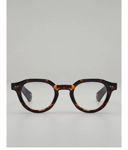 Detail view of tortoiseshell eyewear frame featuring silver rivet accents on polished acetate