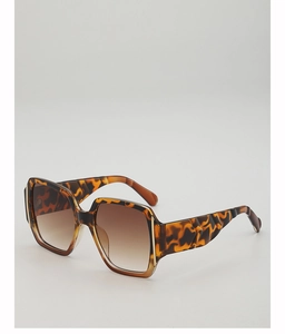 Macro shot of tortoiseshell square frame sunglasses showing textured thick temples and dark lenses