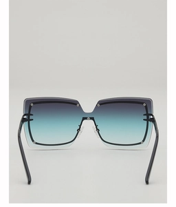 Close-up of oversized square sunglasses with gradient blue lenses and metal rivet details