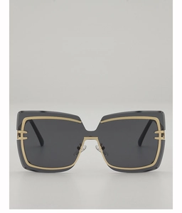 Close-up of oversized square sunglasses with gold metal trim and H-shaped hinge detail