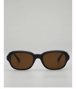 Vue détaillée de la monture noire brillante et des verres teintés marron de ces lunettes de soleil