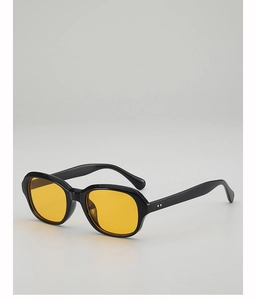 Détail de lunettes de soleil en acétate noir avec verres jaunes et rivets argentés élégants